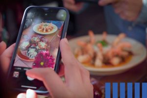 Foodie con iPhone y BellyBro disfrutando platillos gratis